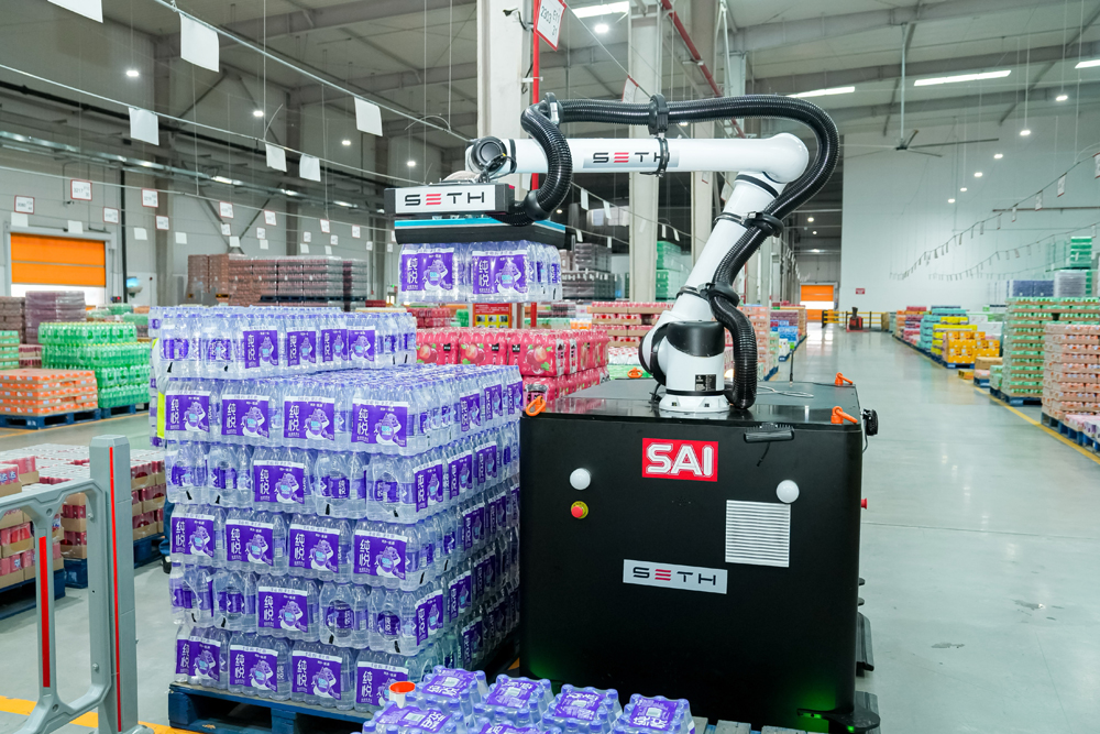 A SAI robot lifts shrink-wrapped beverage packs at Swire Coca-Cola’s Zhengzhou plant.